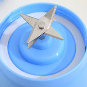 Close-up of stainless steel blades inside blue portable USB juicer blender, highlighting durable and efficient blending design.