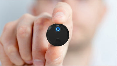 HDQ15 Home Surveillance Camera 1080P shown between fingers, highlighting its compact and portable design for discreet home security.