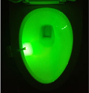 Green light from Toilet Induction LED Night Light inside toilet bowl, battery-powered with motion sensor for hands-free operation.