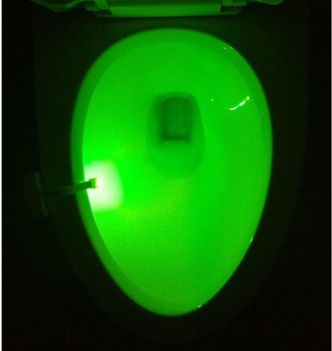 Green light from Toilet Induction LED Night Light inside toilet bowl, battery-powered with motion sensor for hands-free operation.