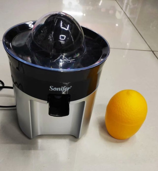 Compact Electric Lemon Juicer Original Manual by Sonifer with dome lid and citrus beside. Sleek design for efficient orange juicing.