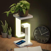 Wireless Charging Floating Lamp used as a plant stand, phone charging on base, stylish multifunctional lighting for home decor.