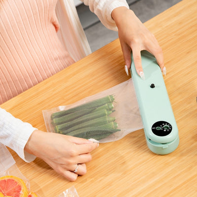 Household Vacuum Sealer - Compact Machine sealing okra in vacuum bag. 110W, 220V device ideal for preserving vegetables in home kitchens.