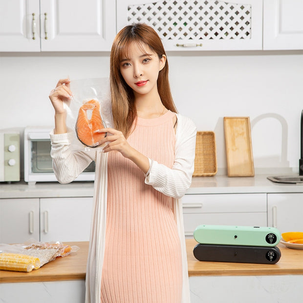 Woman holding vacuum-sealed salmon using Household Vacuum Sealer - Compact Machine. Perfect for kitchen food storage and freshness.