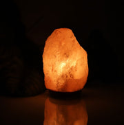 Crystal Salt Lamp Night Light glowing warmly in a dark room, ideal for cozy bedroom lighting and soothing atmosphere.