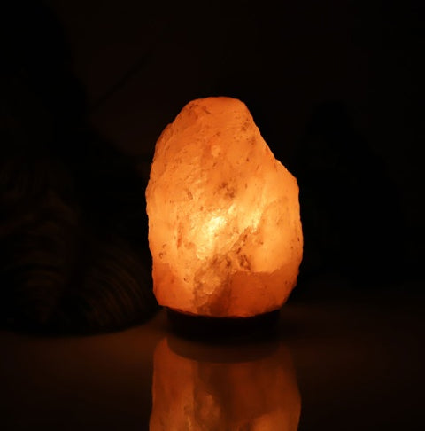 Crystal Salt Lamp Night Light glowing warmly in a dark room, ideal for cozy bedroom lighting and soothing atmosphere.