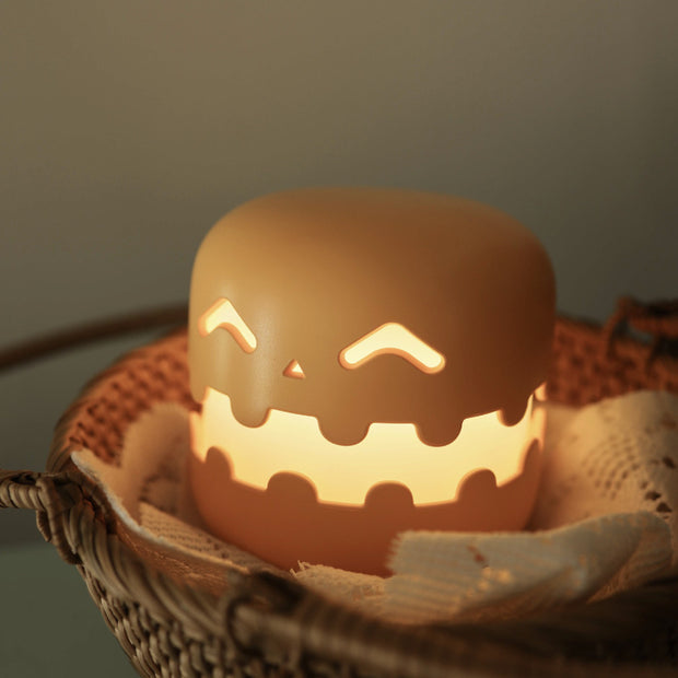 Pumpkin Bedside Lamp - Halloween Decor placed in a woven basket, glowing warmly for cozy night ambiance in kids' rooms.