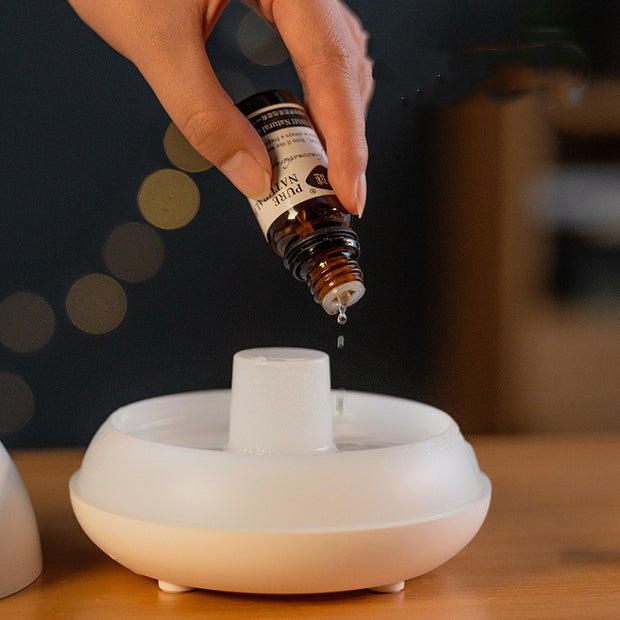 Essential oil being added to the Flame Aromatherapy USB Diffuser for a soothing aromatic experience and sleep support.