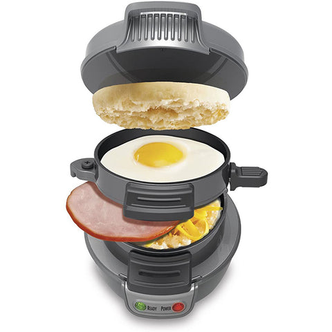 Gray multifunctional sandwich maker showing layered cooking of egg, ham, and muffin, ideal for quick breakfast preparation.
