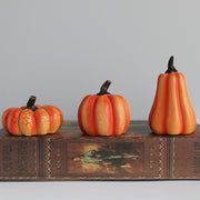 Trio of Halloween Pumpkin LED Lanterns in various shapes on vintage book, perfect for themed displays and cozy seasonal ambiance.