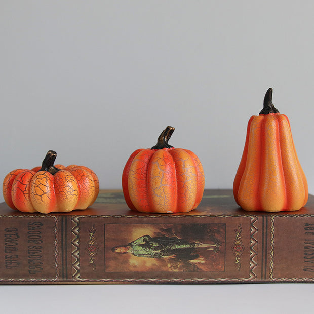 Trio of Halloween Pumpkin LED Lanterns in various shapes on vintage book, perfect for themed displays and cozy seasonal ambiance.